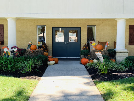 A welcoming entrance adorned with colorful pumpkins and vibrant flowers, capturing the essence of autumn.