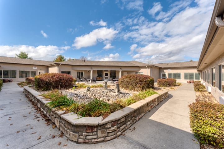 A spacious single-story house with well-maintained landscaping under a bright blue sky.