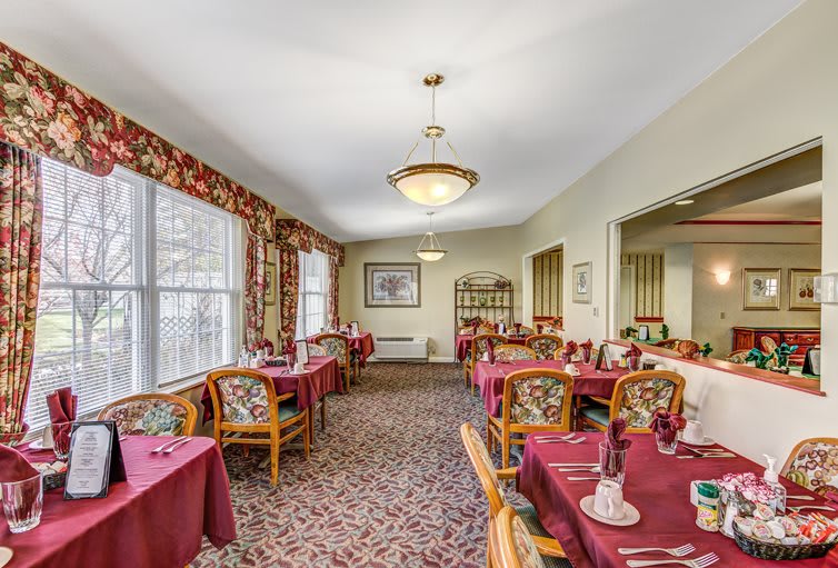A cozy dining room with elegantly set tables and warm lighting.