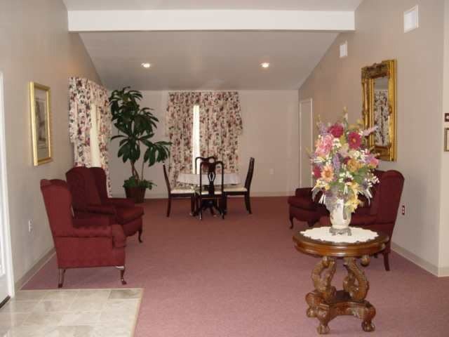 A cozy living room with vintage furnishings and a soft carpeted floor.
