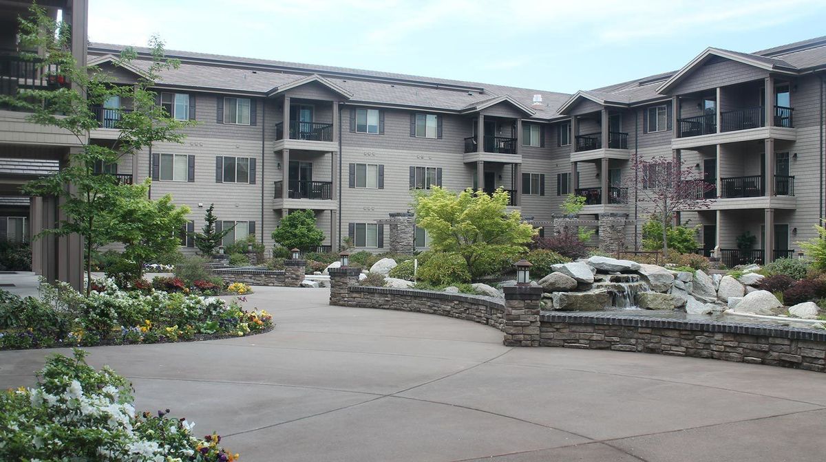 A residential apartment complex with landscaped surroundings.