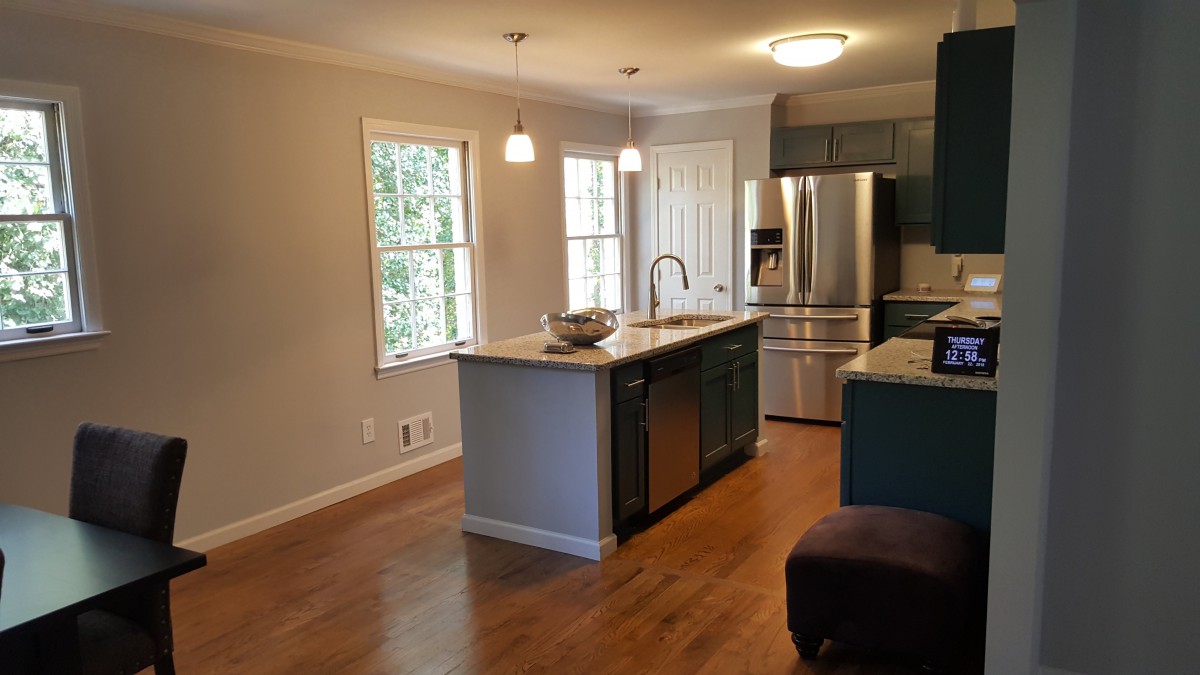 A modern kitchen featuring stainless steel appliances and an island counter with pendant lighting.
