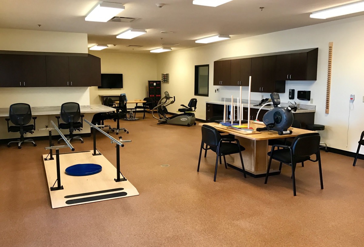 A well-equipped physical therapy clinic with various exercise machines and rehabilitation tools.