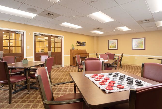 A cozy game room with tables and a checkers board set up for play.