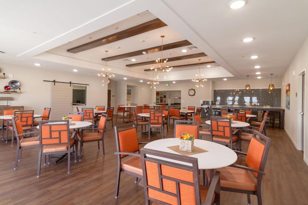 A modern dining area with neatly arranged tables and chairs in a well-lit setting.