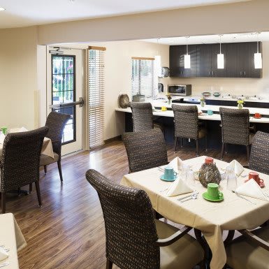 A modern dining area with a table set and an adjacent kitchen.