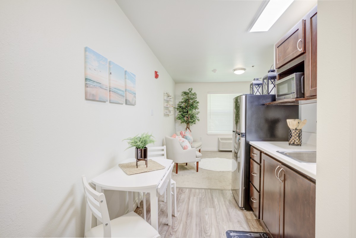 A modern and bright kitchen space featuring a small dining table, appliances, and stylish decor.