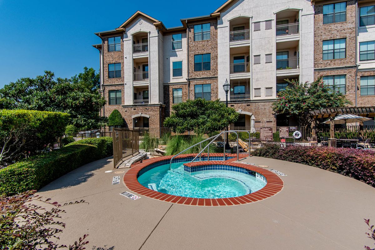 An inviting hot tub surrounded by a well-maintained residential apartment complex.