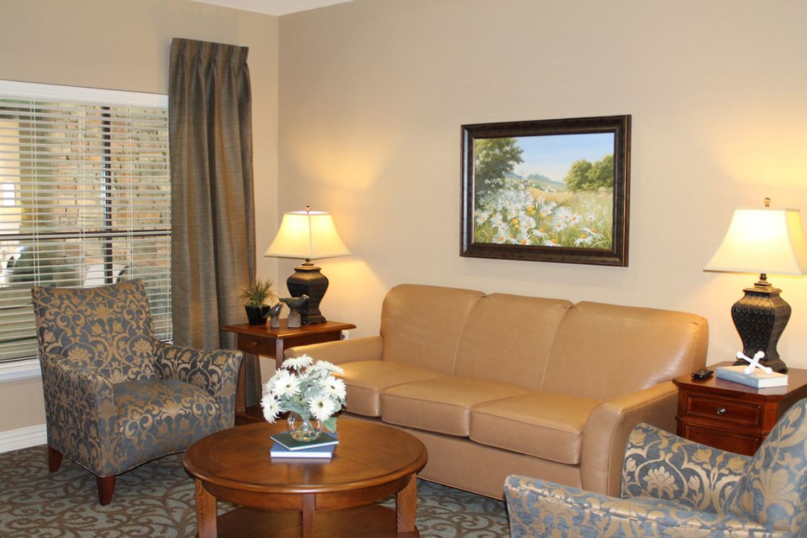 A cozy living room with a sofa and a coffee table, featuring tasteful decor and artwork.