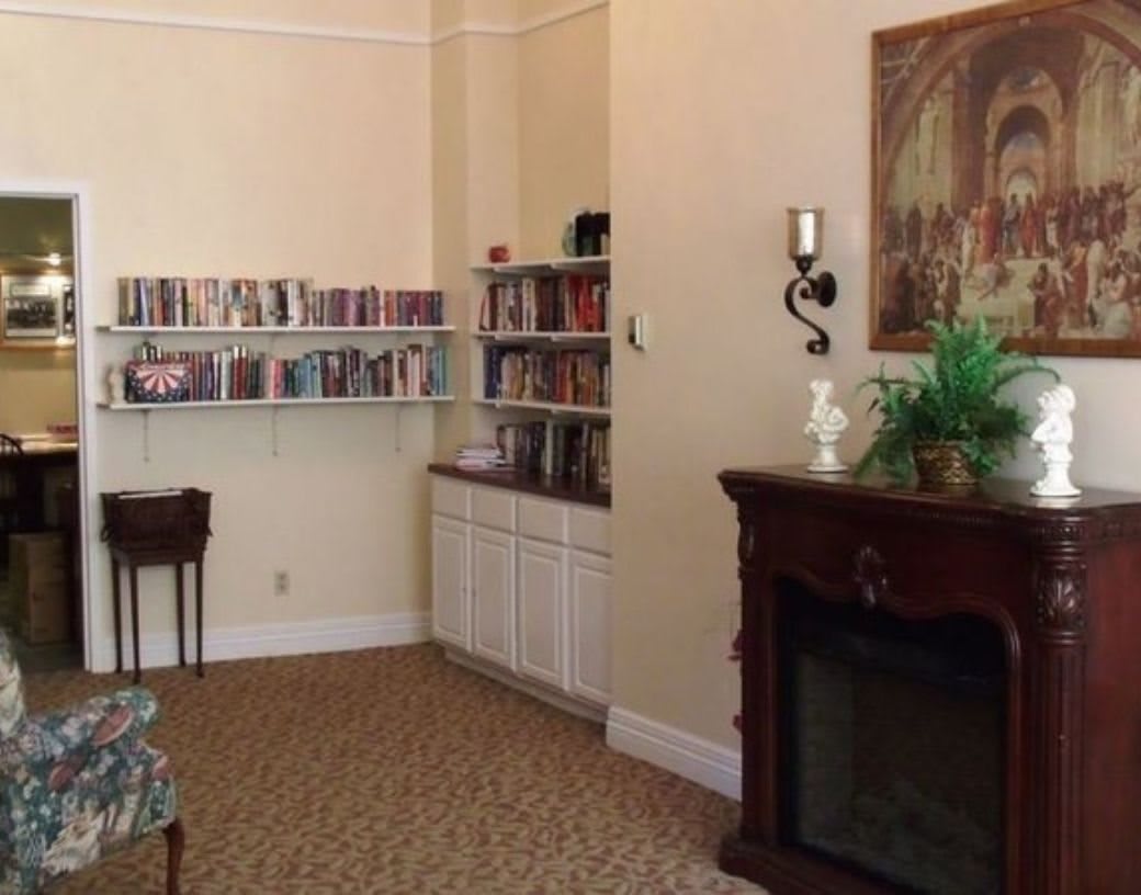 A cozy room with bookshelves and a fireplace.