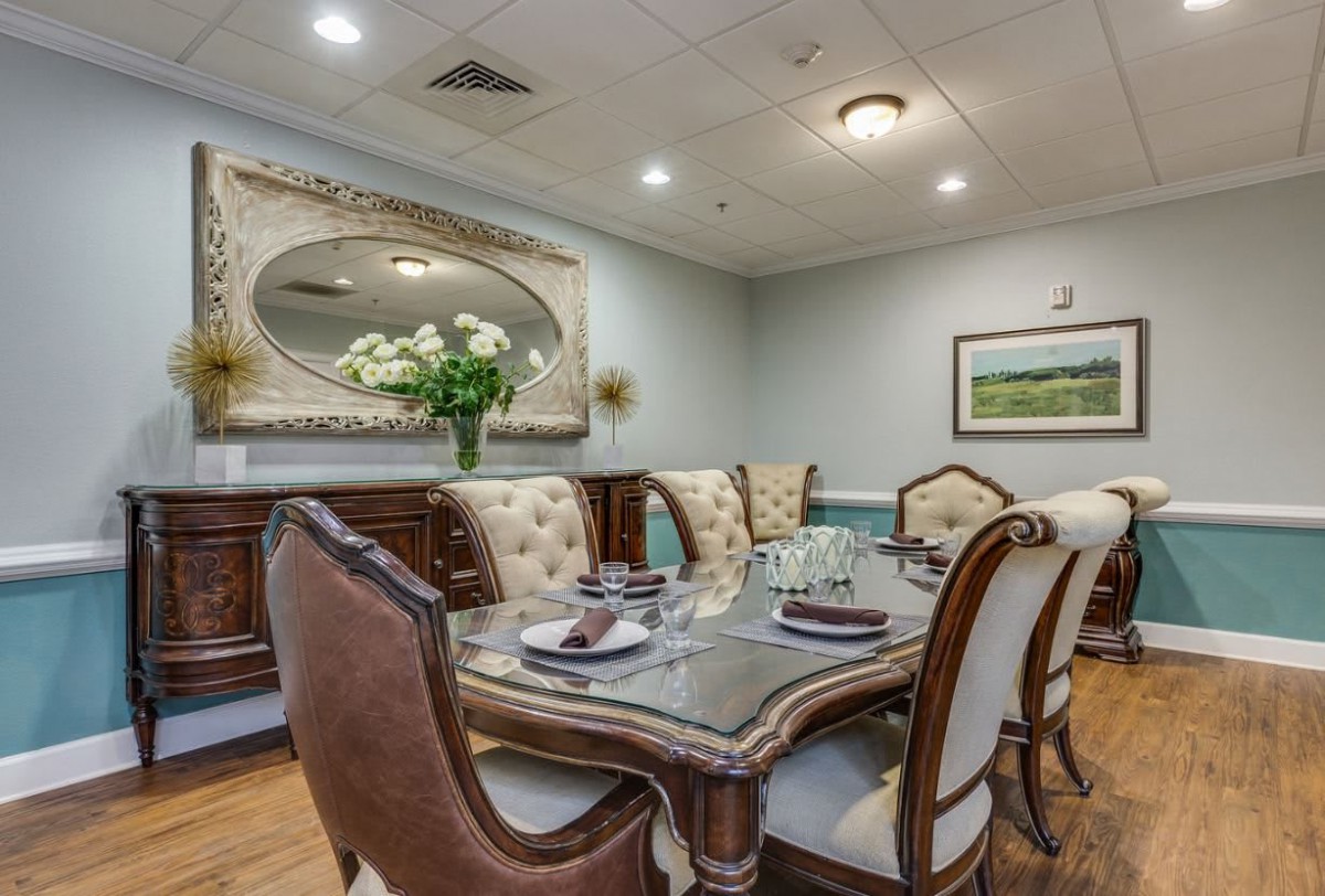 A beautifully set dining room featuring elegant furniture and a large decorative mirror.