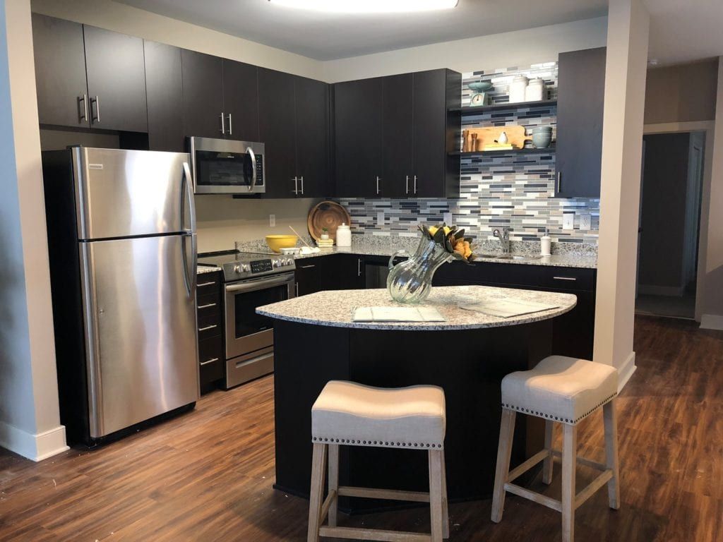 A modern kitchen with stainless steel appliances and a stylish backsplash.