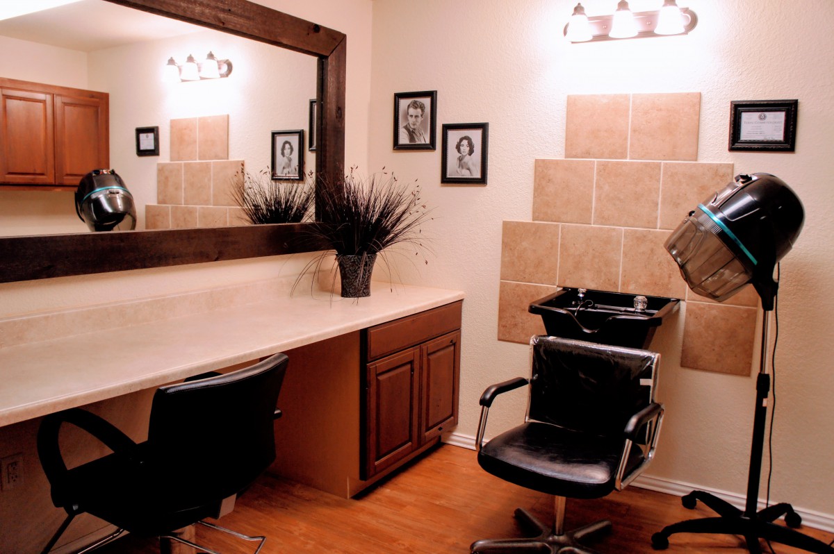 A modern hair salon interior with a styling station and washing area.