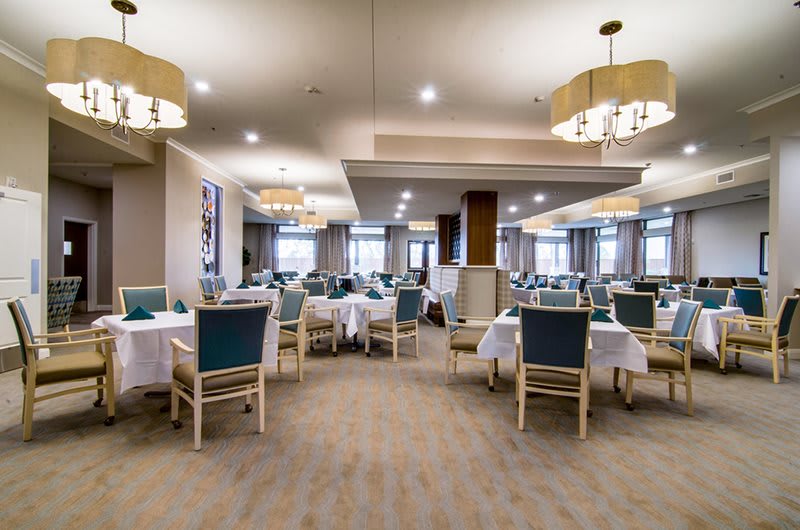 A spacious dining room with neatly arranged tables and elegant lighting.
