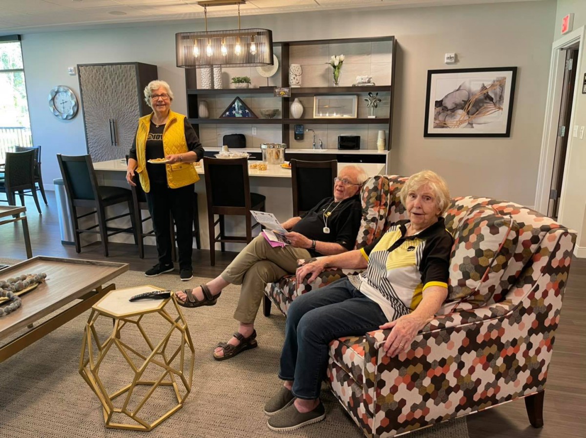 A cozy living room scene with three people relaxing and interacting.