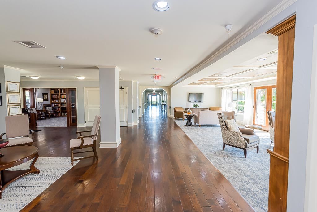 A bright and spacious hallway with wood flooring and comfortable seating areas.