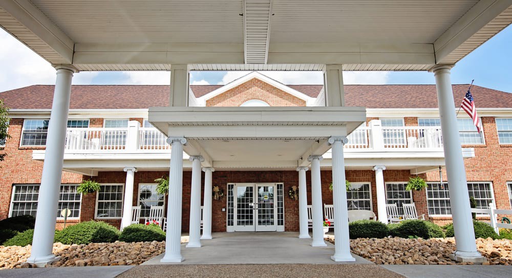 A view of a building entrance featuring white columns and a covered walkway.