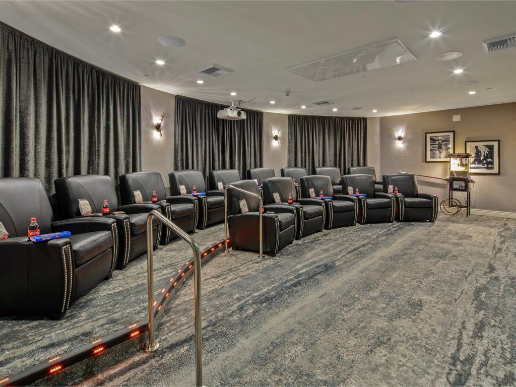 A luxurious home theater with comfortable reclining chairs arranged in rows, perfect for an immersive movie experience.