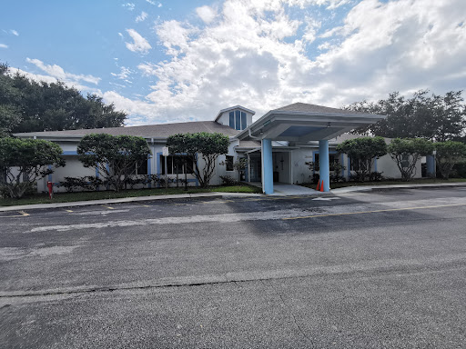 A view of a well-maintained residential building under a partly cloudy sky.