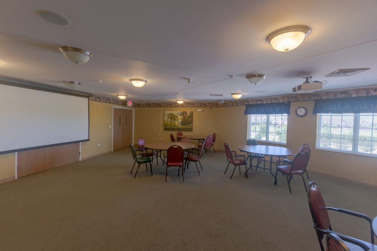 A spacious conference room with tables and chairs arranged for a meeting.