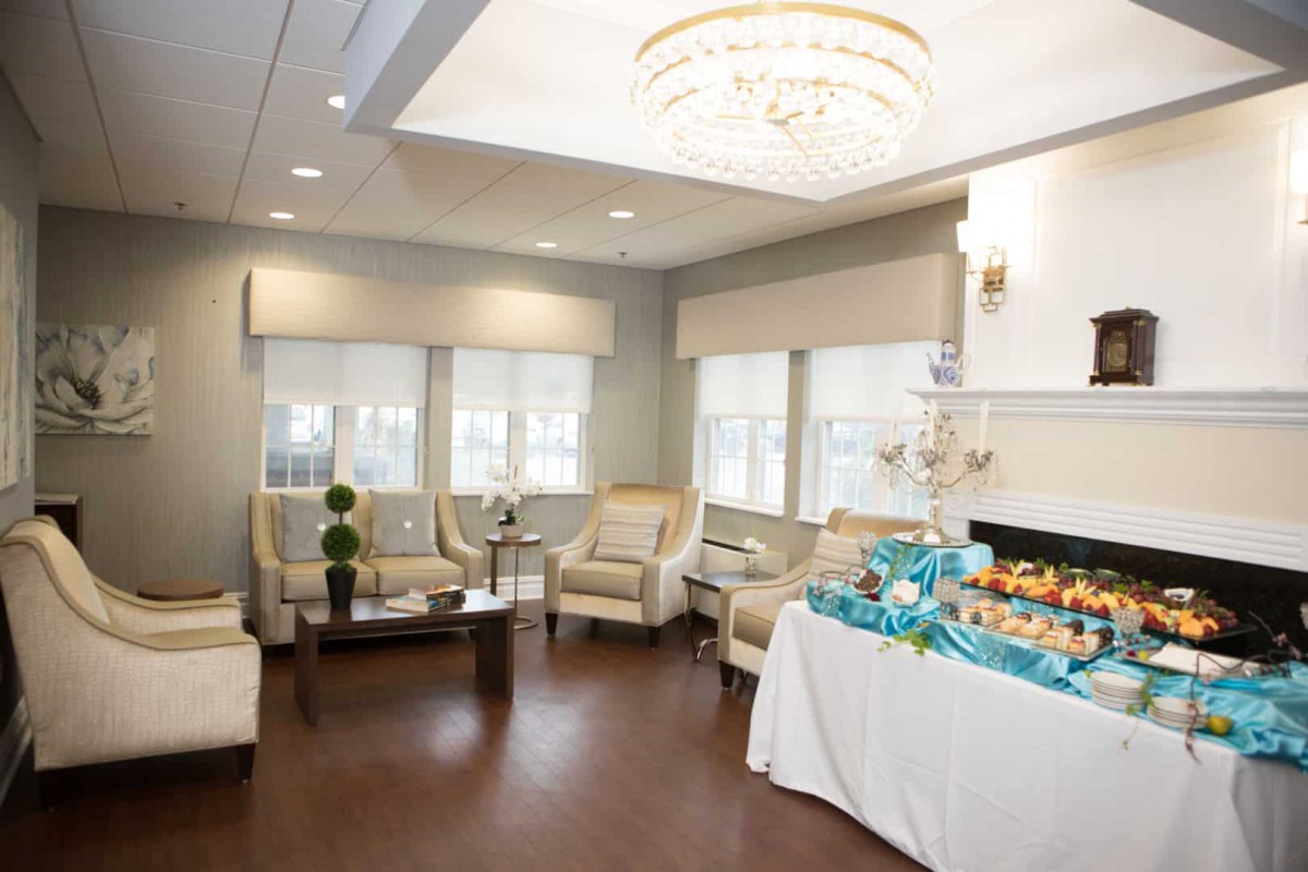 A modern living room with elegant furniture and a decorative chandelier.