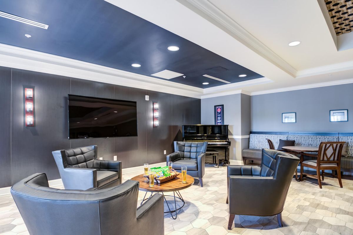 A modern lounge area with a large TV and comfortable seating.