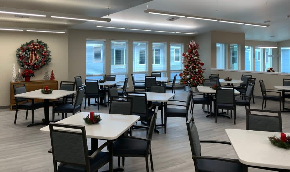 An empty dining room with a Christmas tree and festive decorations.