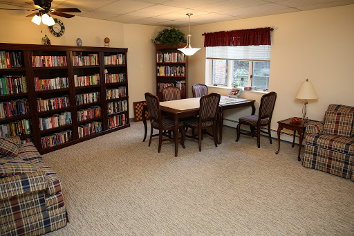 A cozy and well-lit interior space featuring bookshelves, a dining table, and comfortable seating.