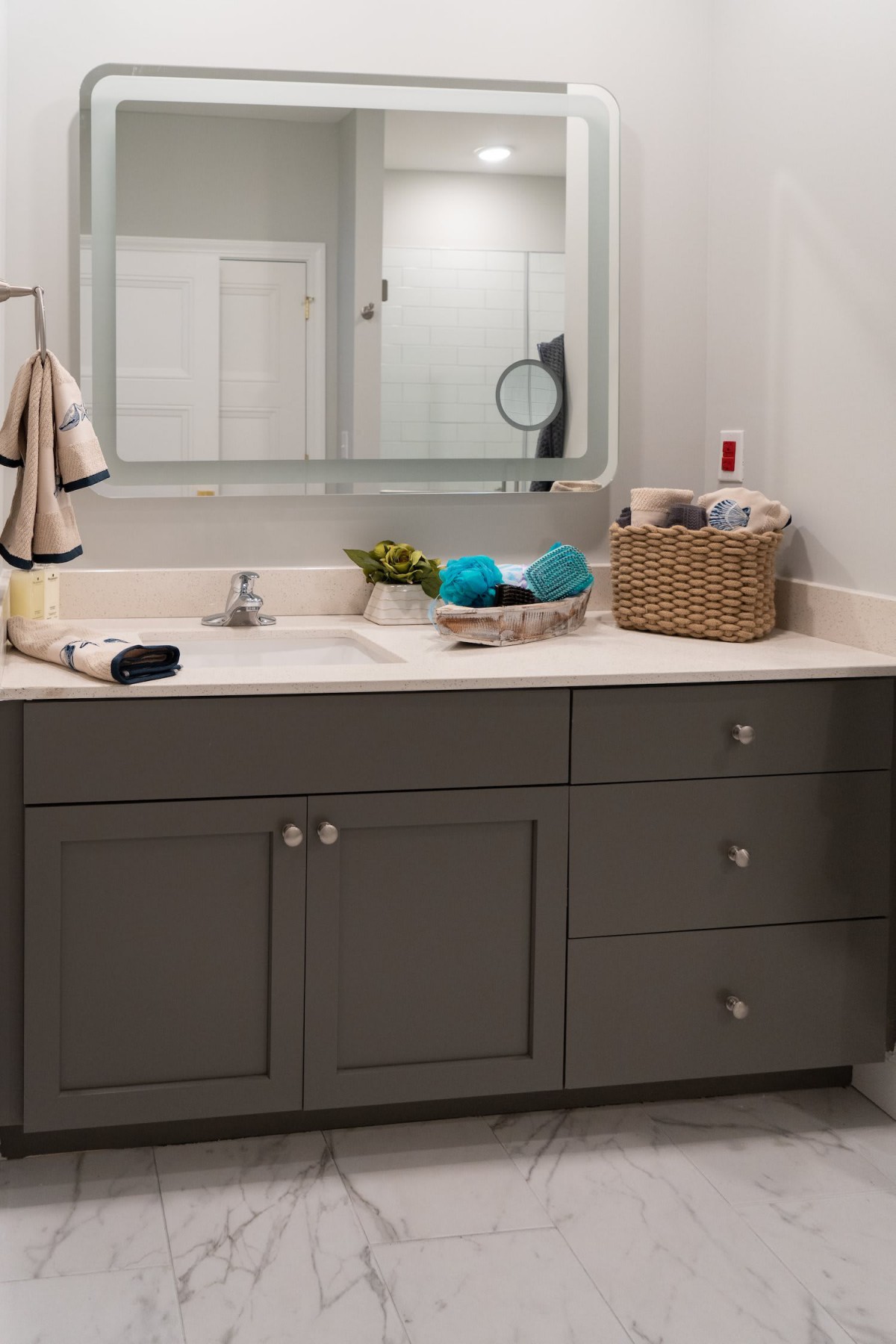 A well-organized bathroom vanity with a mirror, sink, towels, and toiletries.