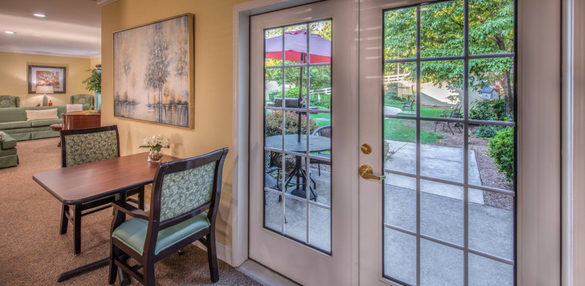 A cozy interior view featuring a glass patio door with an outdoor garden scene.