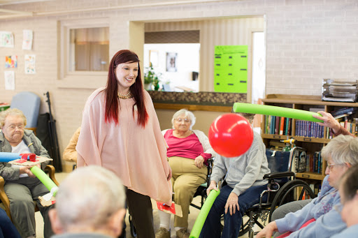 A lively moment in a care facility where residents engage in a fun activity with balloons.