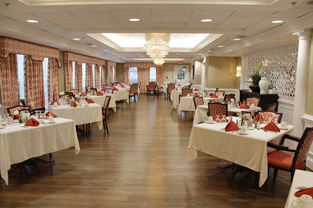 An elegantly decorated dining room with neatly arranged tables and a chandelier.
