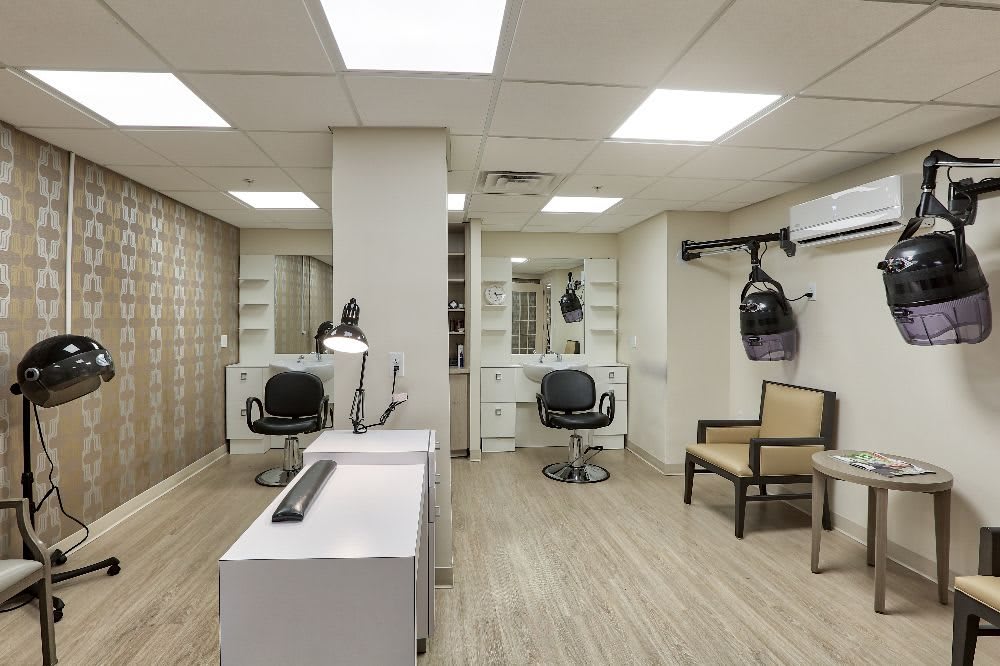 A modern hair salon interior with styling stations and bright lighting.