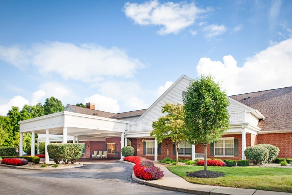 A well-maintained building with landscaped surroundings and a driveway under a cloudy sky.