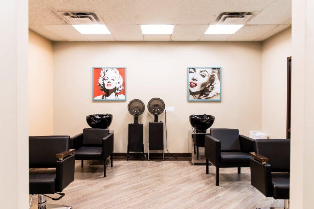 A modern hair salon interior with stylish artwork and seating.