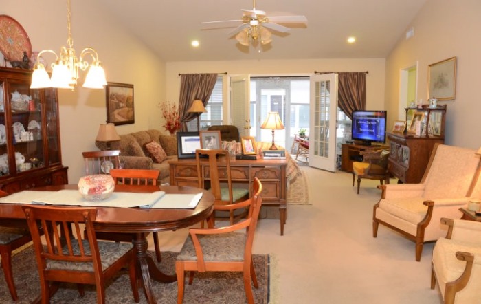 A cozy living room with a combined dining area, featuring comfortable seating, a television, and warm lighting.