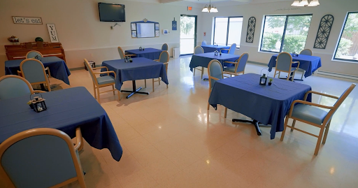 A spacious dining area with blue tablecloths on the tables, creating a calm and inviting atmosphere.
