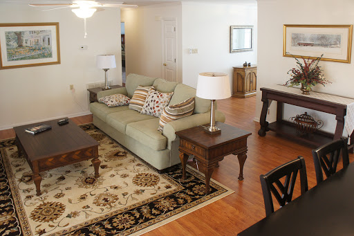 A cozy living room setup featuring a comfortable sofa, decorative pillows, a coffee table, and stylish lamps.