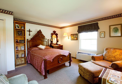A cozy vintage-style bedroom featuring a wooden bed, bookshelf, and warm natural lighting.