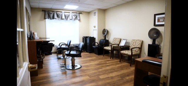 A modern hair salon interior with styling chairs and a waiting area.
