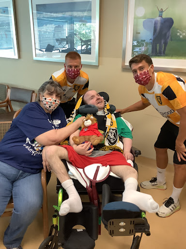 A heartfelt moment shared between caregivers and a loved one in a hospital setting.