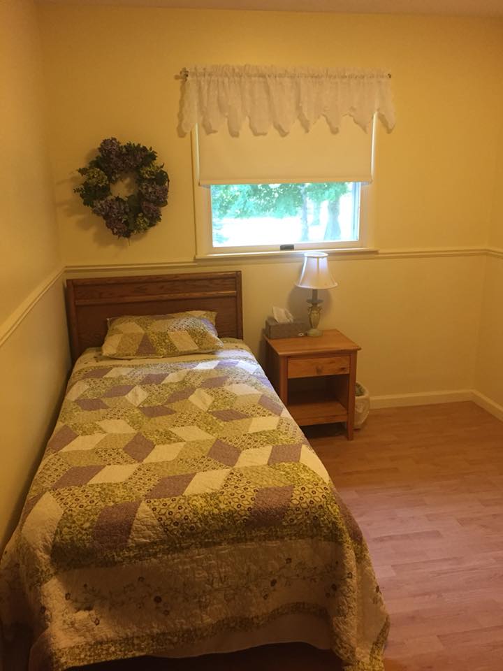 A cozy bedroom with a single bed and simple decor.
