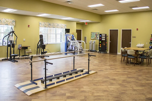 A spacious physical therapy room equipped with various exercise machines and rehabilitation tools.