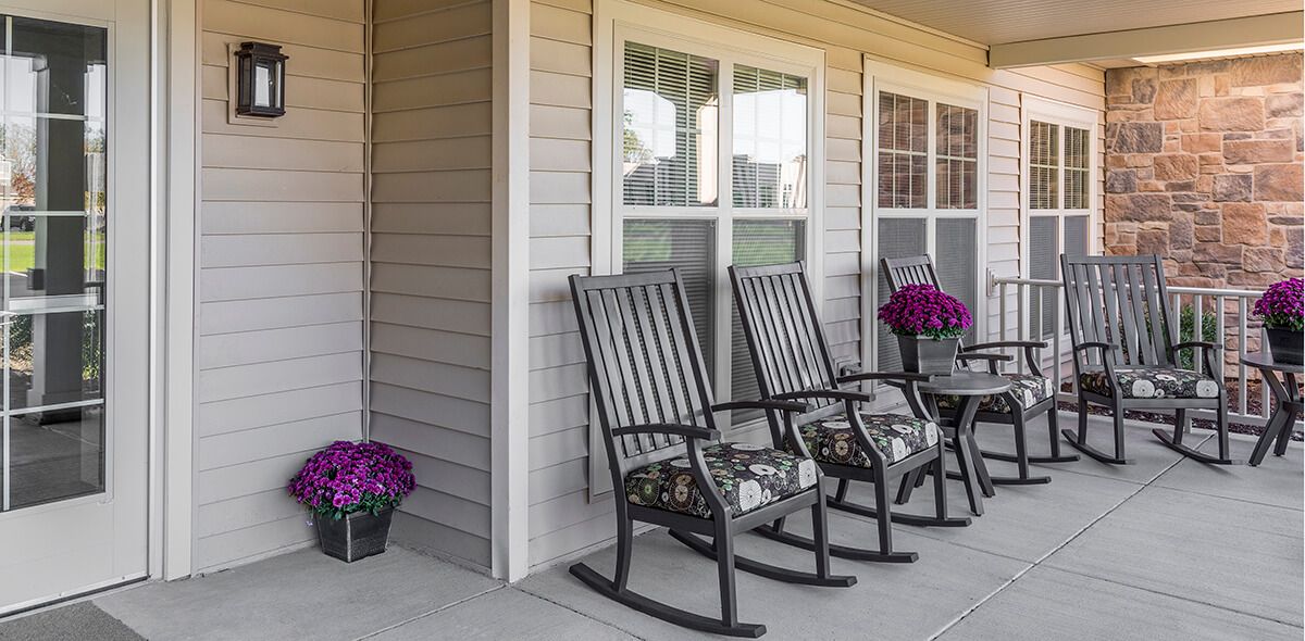 A cozy porch with rocking chairs and vibrant flowers.