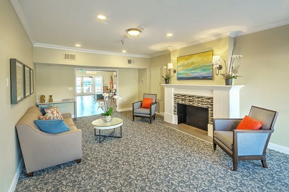 A cozy living room with comfortable seating, a fireplace, and vibrant artwork.