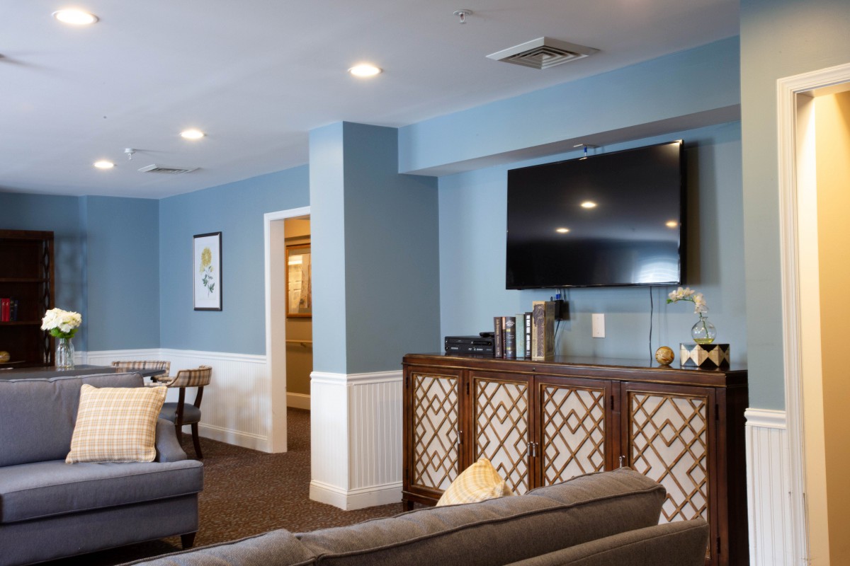 A cozy living room with blue walls, featuring a television and comfortable furniture.