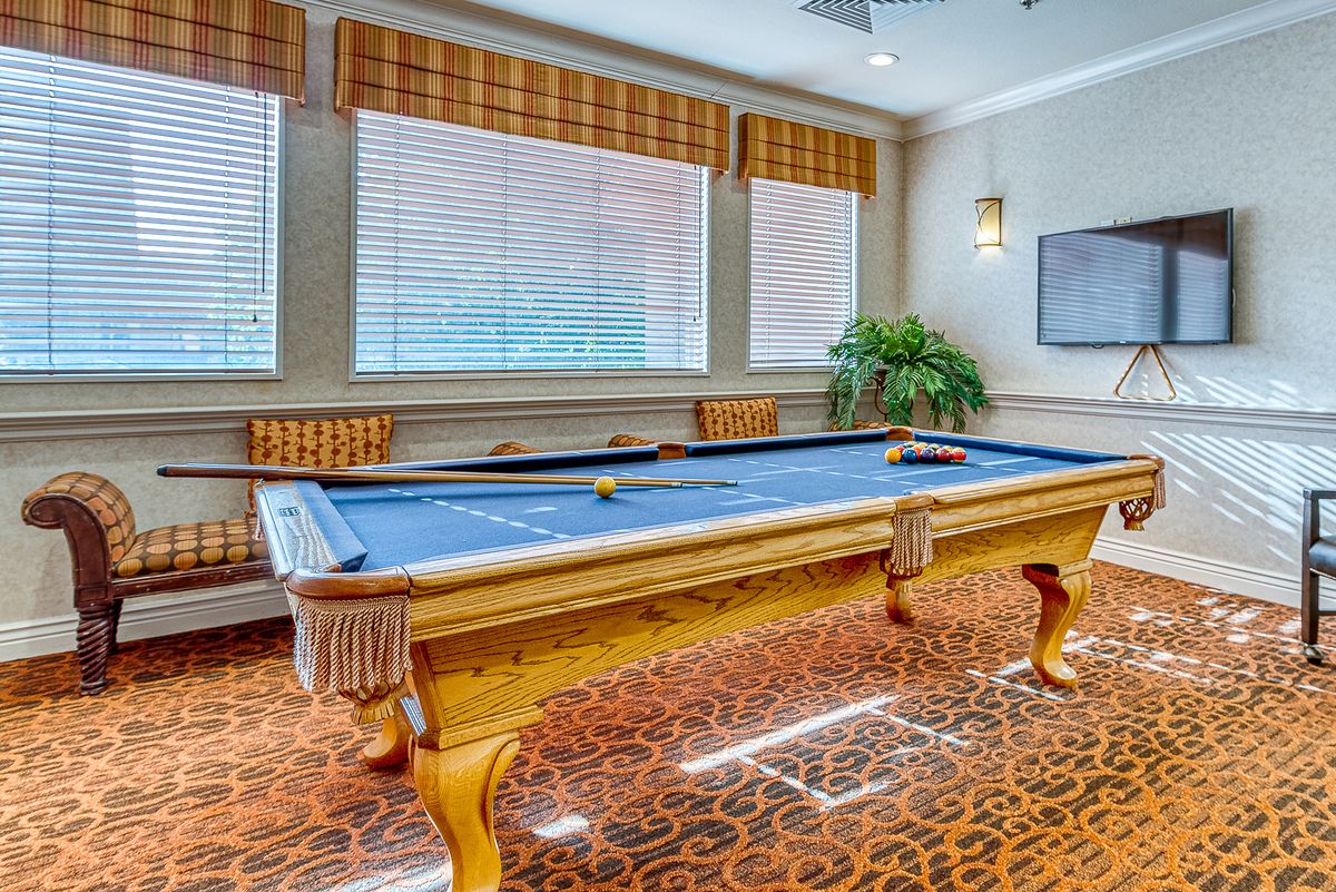 A well-furnished game room featuring a pool table with elegant decor.