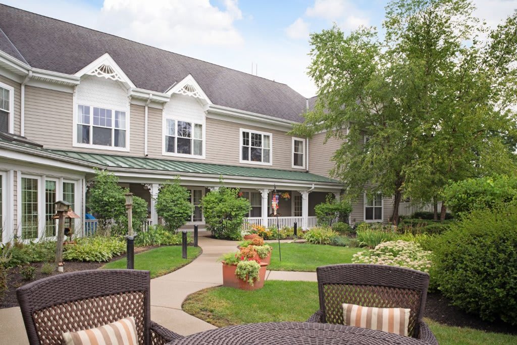 A tranquil garden courtyard with outdoor seating in front of a residential building.