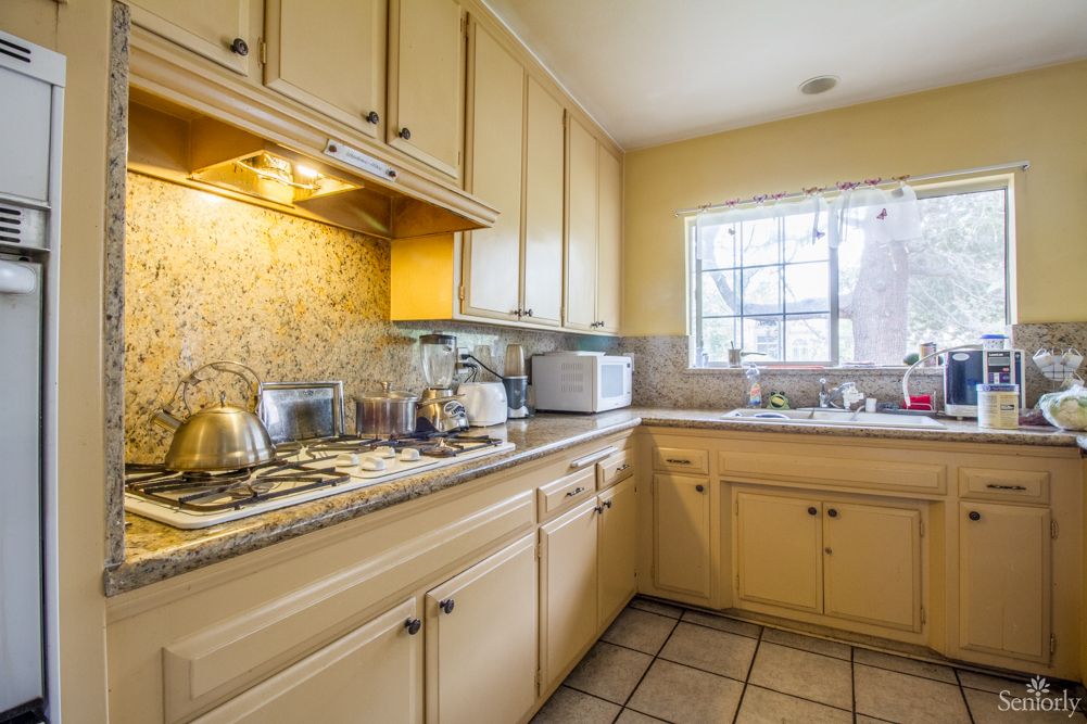 A cozy, well-lit kitchen with wooden cabinets and modern appliances.