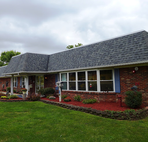 A charming brick house with a well-maintained lawn and landscaping.